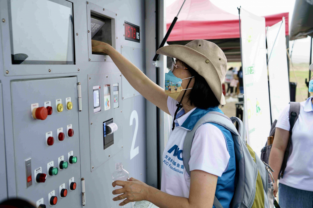 志工們將拾起的寶特瓶投入「好歸塑專車」，讓廢棄塑料空瓶可以直接粉碎、縮小體積，未來將可再製成購物袋、寶特衣、悠遊卡等生活用品